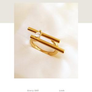 May include: Gold plated ring with a single clear stone set in a geometric design.  Made to order.