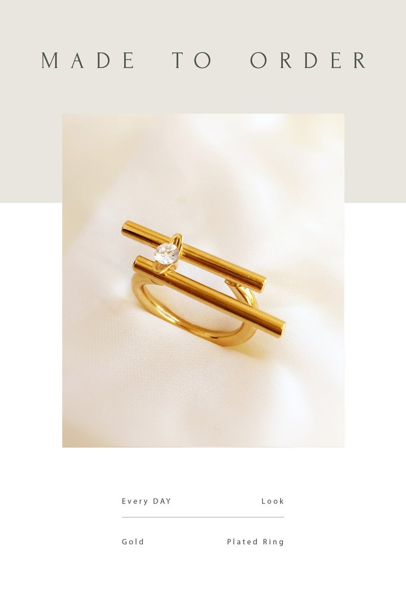 May include: Gold plated ring with a single clear stone set in a geometric design.  Made to order.