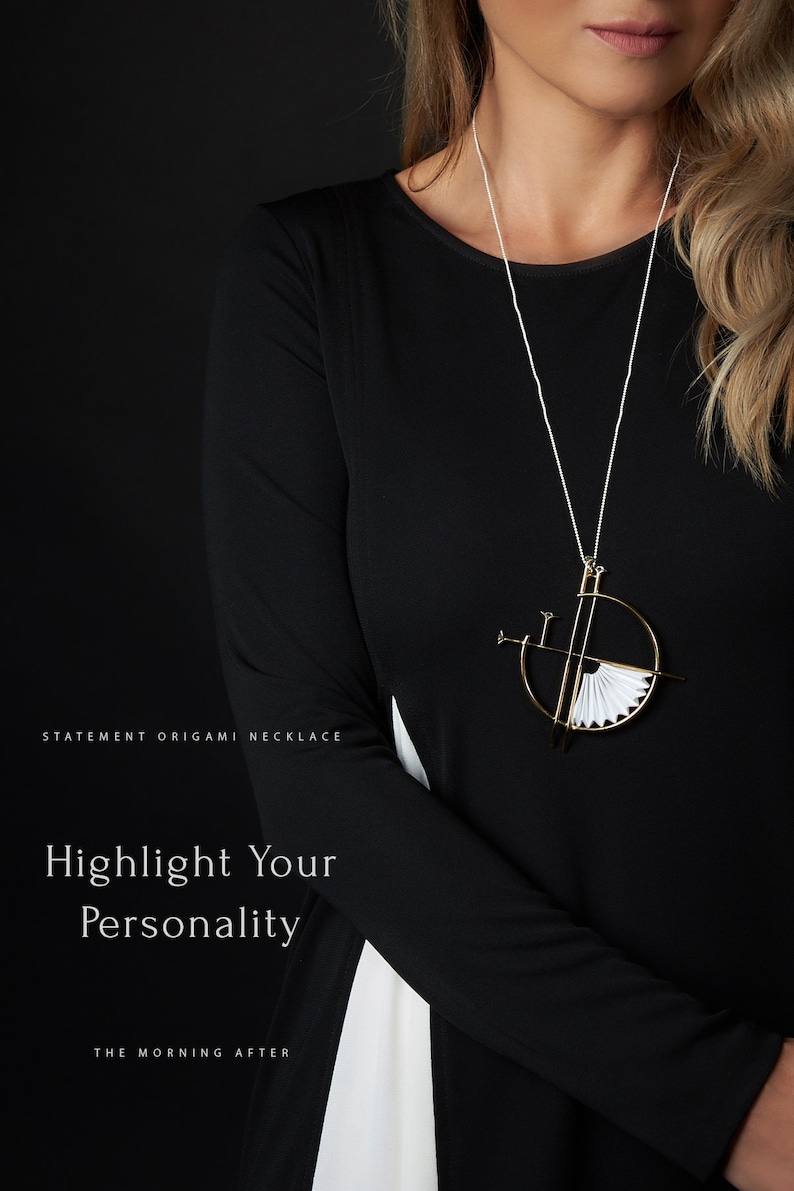 Puede incluir: Una mujer lleva una camisa negra con un collar de origami blanco. El collar est&aacute; hecho de papel doblado y tiene un marco de metal dorado. El texto "STATEMENT ORIGAMI NECKLACE" est&aacute; en la parte inferior izquierda de la imagen. El texto "Highlight Your Personality" est&aacute; en el centro de la imagen. El texto "THE MORNING AFTER" est&aacute; en la parte inferior central de la imagen.