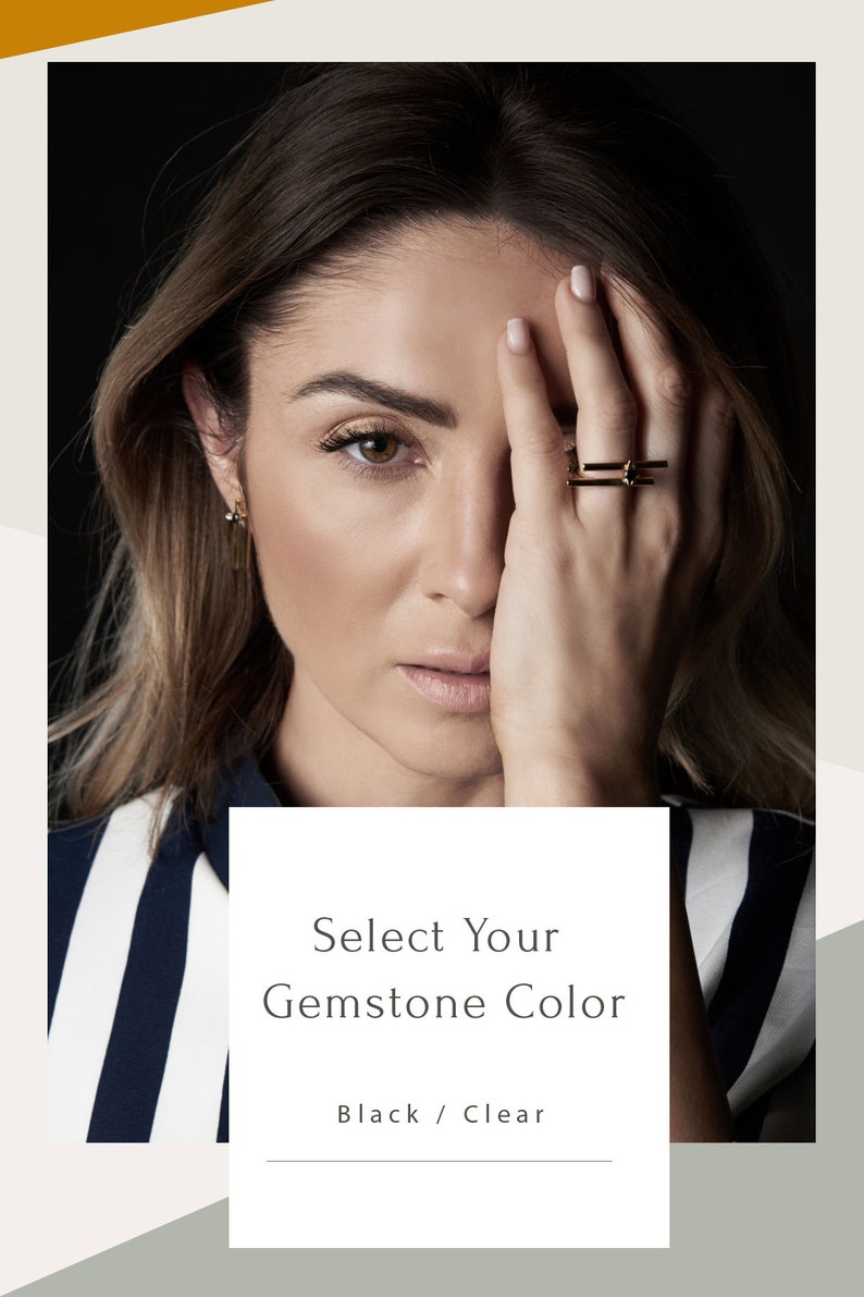 May include: A close-up of a woman's hand wearing a gold ring with a black gemstone. The text "Select Your Gemstone Color" and "Black / Clear" is displayed below the image.