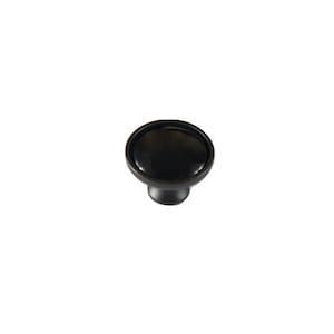 May include: Black round cabinet knob with a slightly raised center.