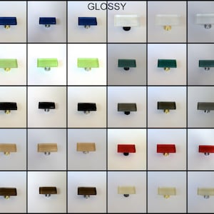 May include: A chart of 10 different colored glass cabinet knobs with a glossy finish. The knobs are arranged in a grid with five rows and four columns. The colors are blue, mint, black, desert, mocha, white, teal, charcoal, red, and cream.
