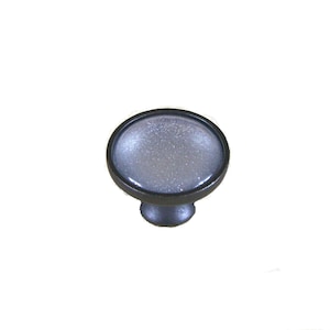 May include: A silver and black round cabinet knob with a sparkly finish.
