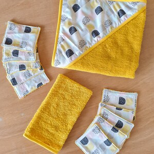 May include: A set of six yellow hooded towels with a geometric pattern in black, white, and yellow. The towels are made of soft, absorbent fabric and are perfect for drying off after a bath or shower.