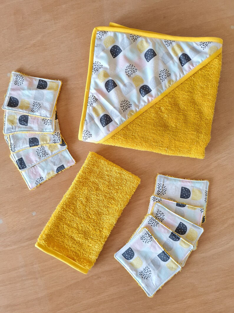 May include: A set of six yellow hooded towels with a geometric pattern in black, white, and yellow. The towels are made of soft, absorbent fabric and are perfect for drying off after a bath or shower.