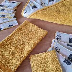 May include: A set of yellow hooded towels and washcloths with a geometric pattern. The towels and washcloths are made of a soft, absorbent material.