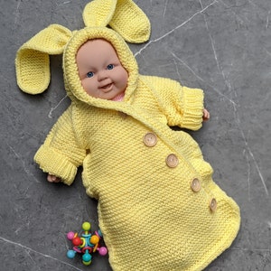 Puede incluir: Un disfraz de conejito de punto amarillo para bebé con capucha y cierre de botones. El disfraz está hecho de hilo suave y tiene un lindo diseño de orejas de conejo.