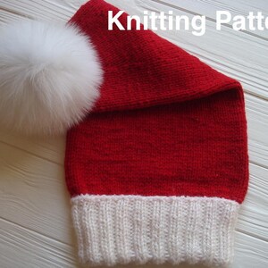 May include: Red knitted hat with a white pom pom and white trim. The hat is folded over at the top and has a knitted texture.