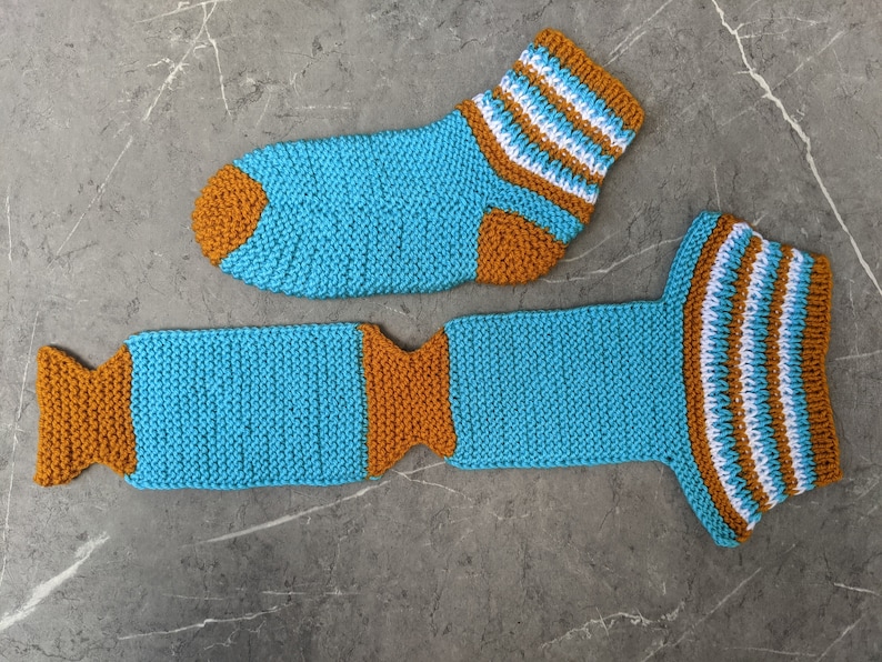 Puede incluir: Un par de calcetines de punto en azul, blanco y naranja. Los calcetines son a rayas y tienen un dise&ntilde;o &uacute;nico.