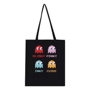 May include: Black tote bag featuring pixelated ghosts in red, pink, blue, and yellow. The names "Blinky Pinky", "Inky", and "Clyde" are printed below the ghosts. The bag has a black handle.