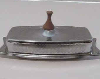 Mantequera de estilo moderno de mediados de siglo con mango de madera y grabado en cromo con forma de hoja.