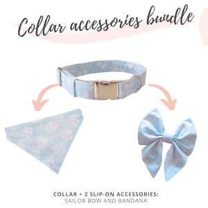 Pode incluir: Um conjunto de coleira azul claro para cães com laço e bandana a condizer. A coleira tem uma fivela prateada e é estampada com pegadas brancas. O texto "Collar accessories bundle" está no topo.