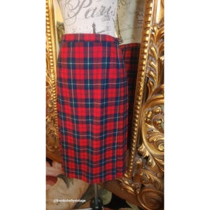 Pode incluir: Uma saia xadrez vermelha, azul e branca. A saia é de comprimento até o joelho e tem uma silhueta reta.