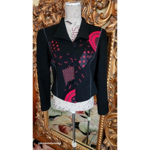 May include: A black blazer with a red and black geometric pattern. The blazer has a collar and button closure.