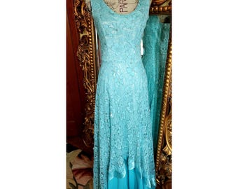 May include: A light blue lace dress with a ruffled hem and a fitted bodice. The dress is on a mannequin and has a vintage style.