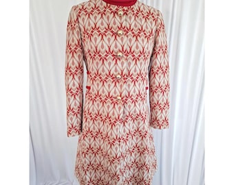 May include: A long-sleeved coat featuring a repeating red and beige geometric pattern. The coat has a high red turtleneck collar and a front button closure with five round gold-toned buttons. The garment is displayed on a mannequin.