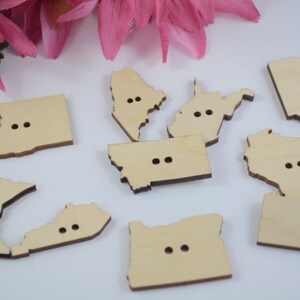 May include: A set of ten wooden buttons shaped like different US states. Each button has two holes for sewing.