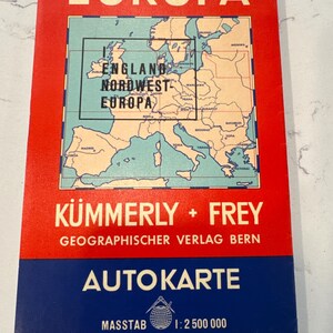 May include: A red and blue vintage map of Europe with the title "EUROPA" in large yellow letters. The map is titled "KÜMMERLY + FREY GEOGRAPHISCHER VERLAG BERN" and "AUTOKARTE" with a scale of "1:2 500 000".
