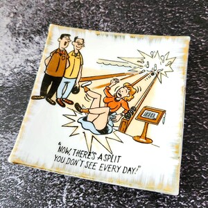 May include: Square ceramic dish with a cartoon illustration. The image depicts two men watching a woman falling, with the text "Now, there's a split you don't see every day!" in black. The dish has a gold trim.