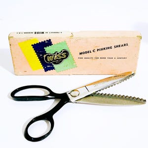 May include: Vintage Model C pinking shears with black handles and a serrated blade, next to its original box. The box is peach-colored with the "Wiss" logo and text that reads "Fine Quality for More Than a Century."