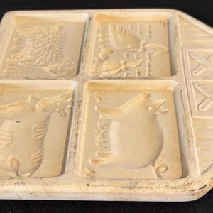 Puede incluir: Un molde de cer&aacute;mica crema vintage con cuatro dise&ntilde;os de animales: un drag&oacute;n, un p&aacute;jaro, un pez y una rana. El molde tiene un extremo en forma de granero con un agujero para colgar, de unos 15 cm de largo.