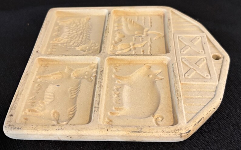 Puede incluir: Un molde de cer&aacute;mica crema vintage con cuatro dise&ntilde;os de animales: un drag&oacute;n, un p&aacute;jaro, un pez y una rana. El molde tiene un extremo en forma de granero con un agujero para colgar, de unos 15 cm de largo.