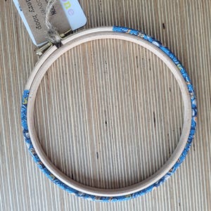 Peut inclure: Un cercle &agrave; broder en bois avec un tissu &agrave; motifs bleus et blancs recouvrant le bord ext&eacute;rieur.