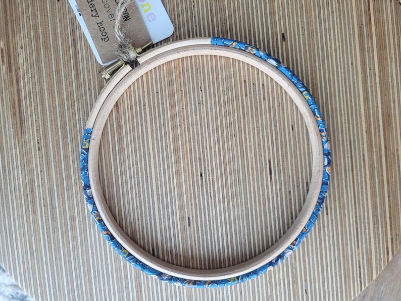 Peut inclure: Un cercle &agrave; broder en bois avec un tissu &agrave; motifs bleus et blancs recouvrant le bord ext&eacute;rieur.