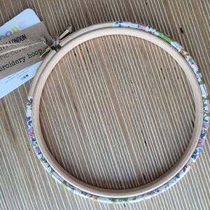 Peut inclure: Un cerceau de broderie en bois avec un rev&ecirc;tement en tissu floral. Le cerceau a un diam&egrave;tre de 15 cm et est fait de bois naturel. Le rev&ecirc;tement en tissu est un imprim&eacute; Liberty London avec une vari&eacute;t&eacute; de couleurs et de motifs.