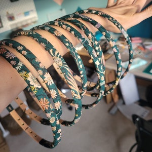 Peut inclure: Un ensemble de 8 bandeaux &agrave; motifs floraux verts. Les bandeaux sont en tissu et ont un design simple.