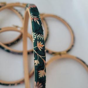 Peut inclure: Un ensemble de quatre cerceaux &agrave; broder recouverts d'un tissu floral vert.