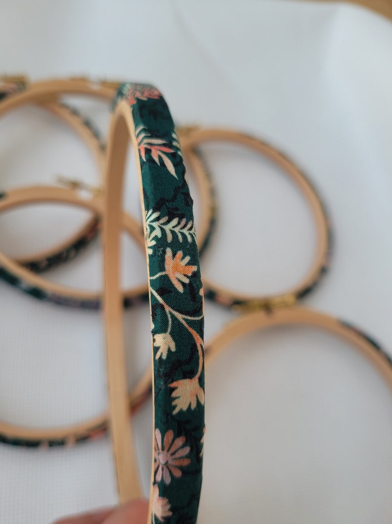 Peut inclure: Un ensemble de quatre cerceaux &agrave; broder recouverts d'un tissu floral vert.