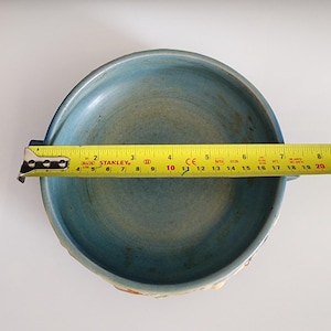 Puede incluir: Un cuenco de cer&aacute;mica azul con una cinta m&eacute;trica amarilla en la parte superior. El cuenco tiene un di&aacute;metro de aproximadamente 50 cm.
