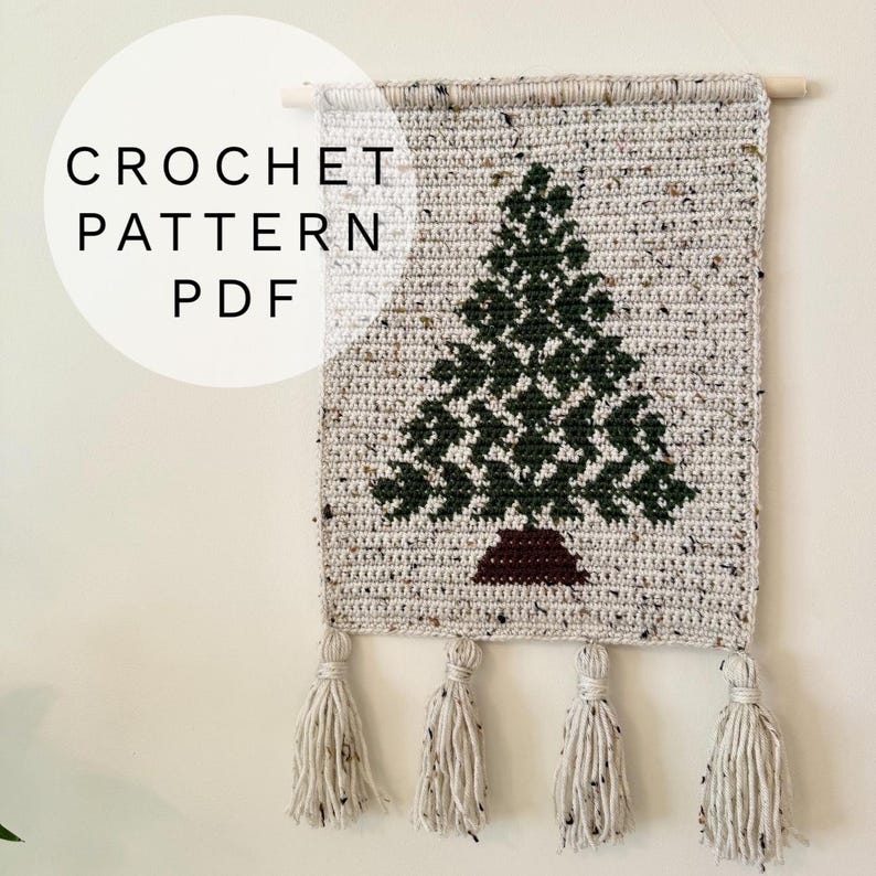 May include: Crocheted wall hanging featuring a green Christmas tree design on a speckled gray background. The text "CROCHET PATTERN PDF" is in a white circle. The piece is finished with four tassels.