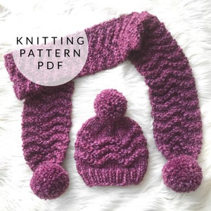 May include: A purple knitted hat and matching scarf with pom-poms. The knitting pattern is available as a PDF download.