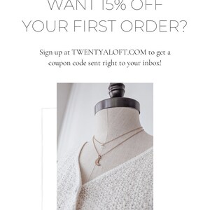 May include: A white sweater with a crescent moon necklace on a mannequin. The text "WANT 15% OFF YOUR FIRST ORDER? Sign up at TWENTYALOFT.COM to get a coupon code sent right to your inbox!" is displayed above the mannequin.