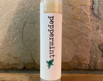 May include: A white tube of peppermint lip balm with a green leaf design and the word "peppermint" printed on the label.