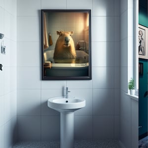 May include: A framed print of a capybara taking a bath in a white bathtub. The capybara is looking directly at the camera. The print is hanging on a white tiled wall in a bathroom.