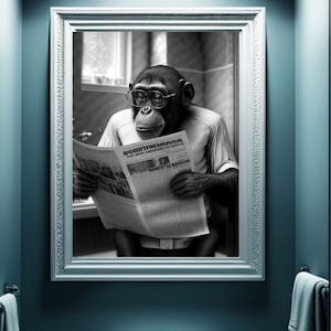 May include: A monochrome image showing a chimpanzee wearing spectacles and a shirt, reading a newspaper reflected in a mirror. The mirror has a white frame, and the bathroom is painted in shades of blue.