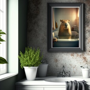 May include: A framed print of a capybara taking a bath in a white bathtub. The capybara is looking directly at the camera. The bathroom is tiled in white and has a window with sunlight streaming in.