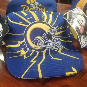May include: A blue and yellow baseball cap with a yellow lightning bolt design and a Rams logo. The cap has a Starter logo on the side.