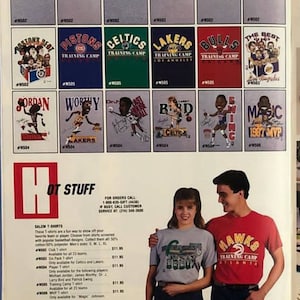 Op de afbeelding: Een pagina uit een catalogus met verschillende NBA-team T-shirts. De shirts bevatten cartoonafbeeldingen van populaire spelers zoals Michael Jordan, Magic Johnson en Larry Bird. De catalogus bevat ook een beschrijving van de shirts en hun prijzen.
