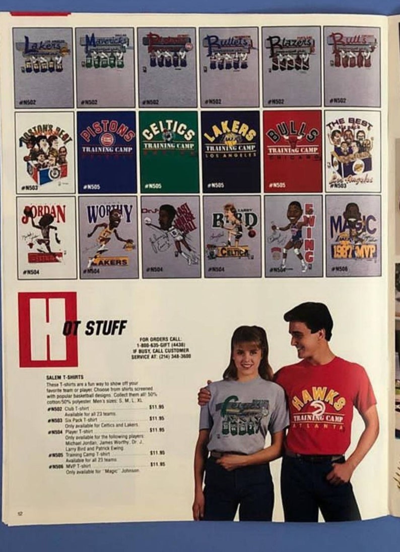 Op de afbeelding: Een pagina uit een catalogus met verschillende NBA-team T-shirts. De shirts bevatten cartoonafbeeldingen van populaire spelers zoals Michael Jordan, Magic Johnson en Larry Bird. De catalogus bevat ook een beschrijving van de shirts en hun prijzen.