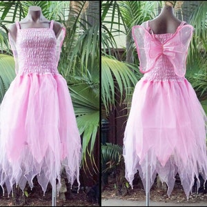 May include: Pink fairy costume with a tulle skirt and sheer wings. The dress has a ruffled bodice and a bow on the back.