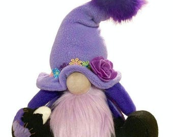 May include: Purple gnome with a purple hat, a pink beard, and black feet. The hat has a purple pom-pom and is decorated with flowers.