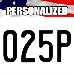 May include: White license plate with black numbers and letters. The plate reads "2025PR" in bold font. The top of the plate features the American flag and the word "PERSONALIZED" in white.