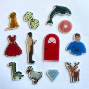 May include: A set of colorful stickers featuring a variety of images, including a dog, a dress, a man, a door, a dolphin, a donut, a man with a blue shirt, a reindeer, a dinosaur, a duck, and a diamond.