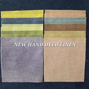 May include: A collection of hand-dyed linen fabric swatches in various colors, including shades of green, blue, and tan. The text "NEW HAND DYED LINEN" is displayed across the image. The fabric squares are arranged in neat rows.