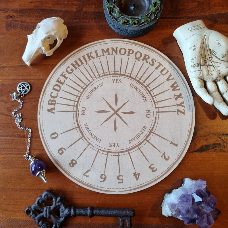 May include: A wooden Ouija board with a planchette, alphabet, numbers, and the words "Yes", "No", "Rephrase", and "Unknown".