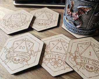 May include: Six hexagonal wooden coasters with a dice design and various phrases. The coasters feature a skull, swords, flowers, and the numbers 1, 7, and 20. The phrases on the coasters are "Dice Goblin", "Have a Plan", "Crit Happens", "Let's Roll", and "Well Shit".